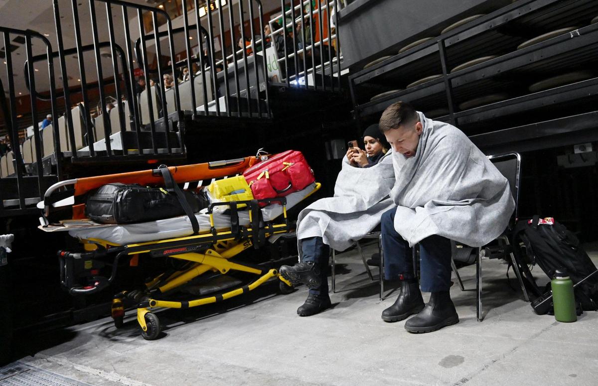 American Ambulance paramedics, on site since 9am, try to keep warm at Selland Arena at the CIF Central Section basketball championships Friday evening, Feb. 24, 2023 in Fresno.