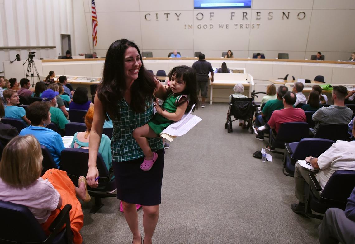 Arte Americas board president Vivian Velasco Paz carries her daughter Gabriela Paz, 2, after speaking in support of parks to the Fresno City Council Thursday, Aug. 9, 2018 in Fresno.