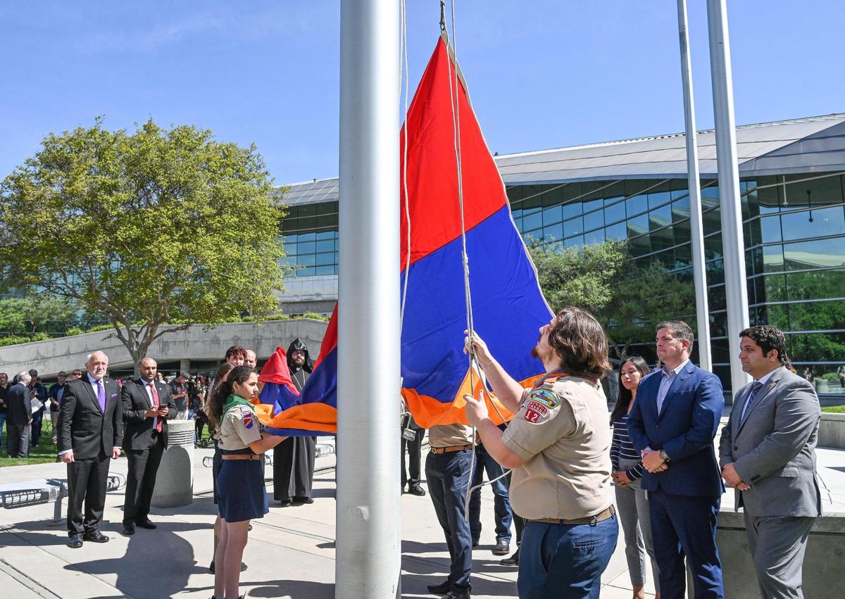 Fresno city and county officials gather around the city’s flag poles as Homenetmen Fresno Sassoon Chapter scouts raise the Armenian flag over Fresno City Hall during the annual Armenian Flag Raising Ceremony to commemorate the start of the Armenian Genocide 108 years ago, on Monday, April 24, 2023.