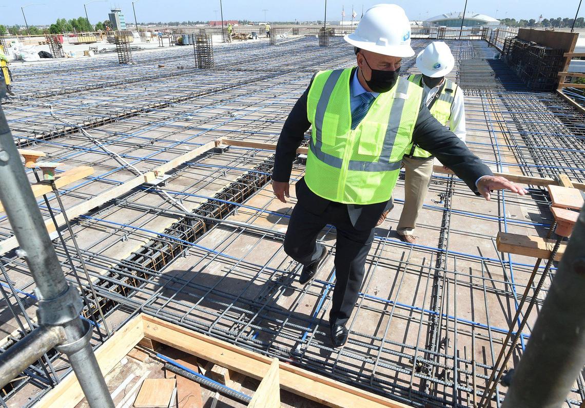 Fresno Mayor Jerry Dyer, front, flanked by the city’s aviation director Kevin Meikle, checks out construction progress on the fourth floor of a new parking structure at the Fresno Yosemite International Airport, April 14, 2021.