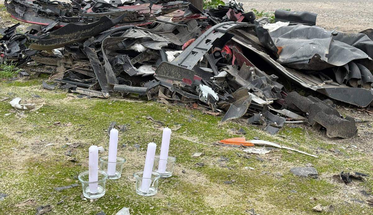 Four candles are set at the intersection of Jefferson Avenue and Walnut Avenue where Samantha and Elena Kellogg died. Vehicle wreckage sits nearby. Photographed Dec. 18, 2025.