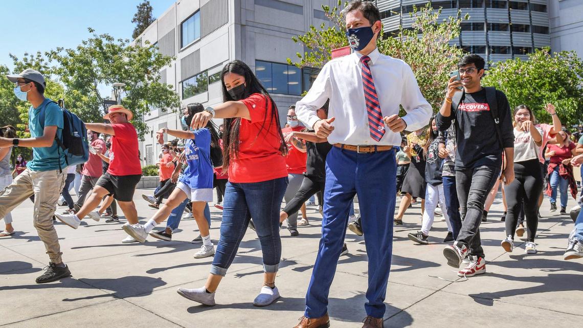Fresno State students, faculty and staff joined by University President Saúl Jiménez-Sandoval, right center, erupt into a flash mob of dancing during a noontime event called “Bulldogs Joyful Together” on campus near the Henry Madden Library on Wednesday, Sept. 8, 2021. Organizers called the event an opportunity for students, staff and faculty to interact and come together in celebration of their return to campus, after nearly a year and a half of working from home and distance learning due to COVID-19 restrictions.