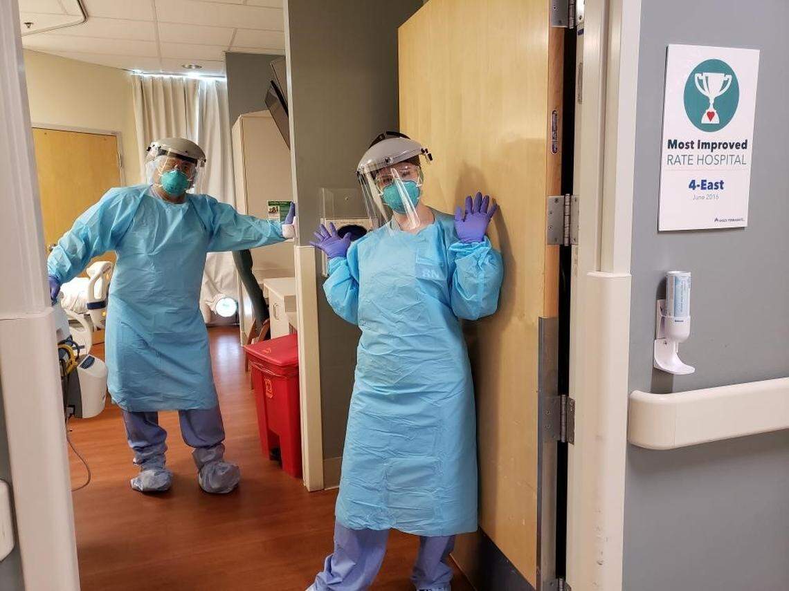 Kaiser Permanente Fresno nurses Stephanie Edwards, right, and Richard Balakid dressed in personal protective equipment at the Fresno hospital.