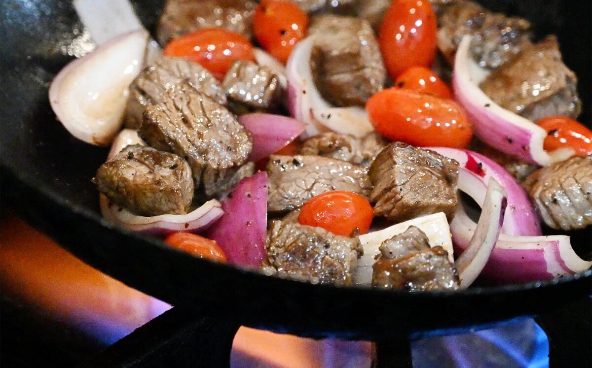 The lomo saltado’s wok-seared beef with onion and tomatoes is prepared at chef Rob Vieira and Andrew Penn’s new The Third Place Global Eatery.