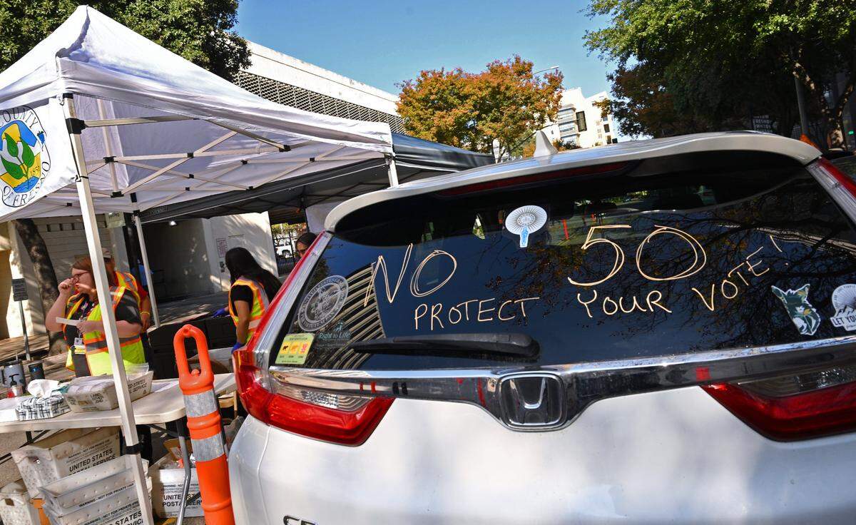 A Prop. 50 political message is seen as cars drive past the voting station outside the Fresno County Elections office on Kern Street Tuesday, Nov. 4, 2025 in Fresno.