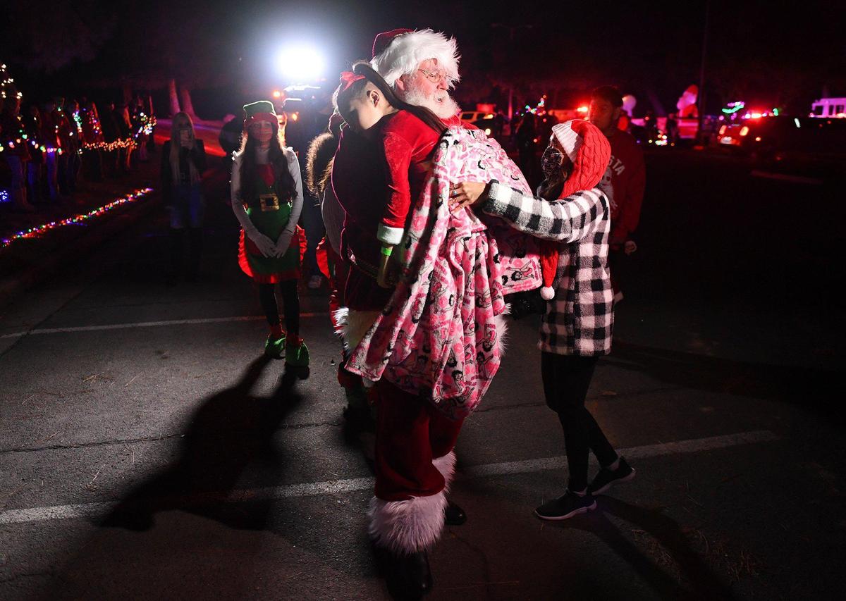 Arianna Jasso, age 6, is carried by Santa as she experiences a special surprise early Christmas, possibly her last, at Woodward Park Saturday night, Nov. 21, 2020 in Fresno. Arianna was diagnosed July 20 with a brain tumor called diffuse intrinsic pontine glioma (DIPG) which carries a life expectancy post-diagnoses of six to nine months.