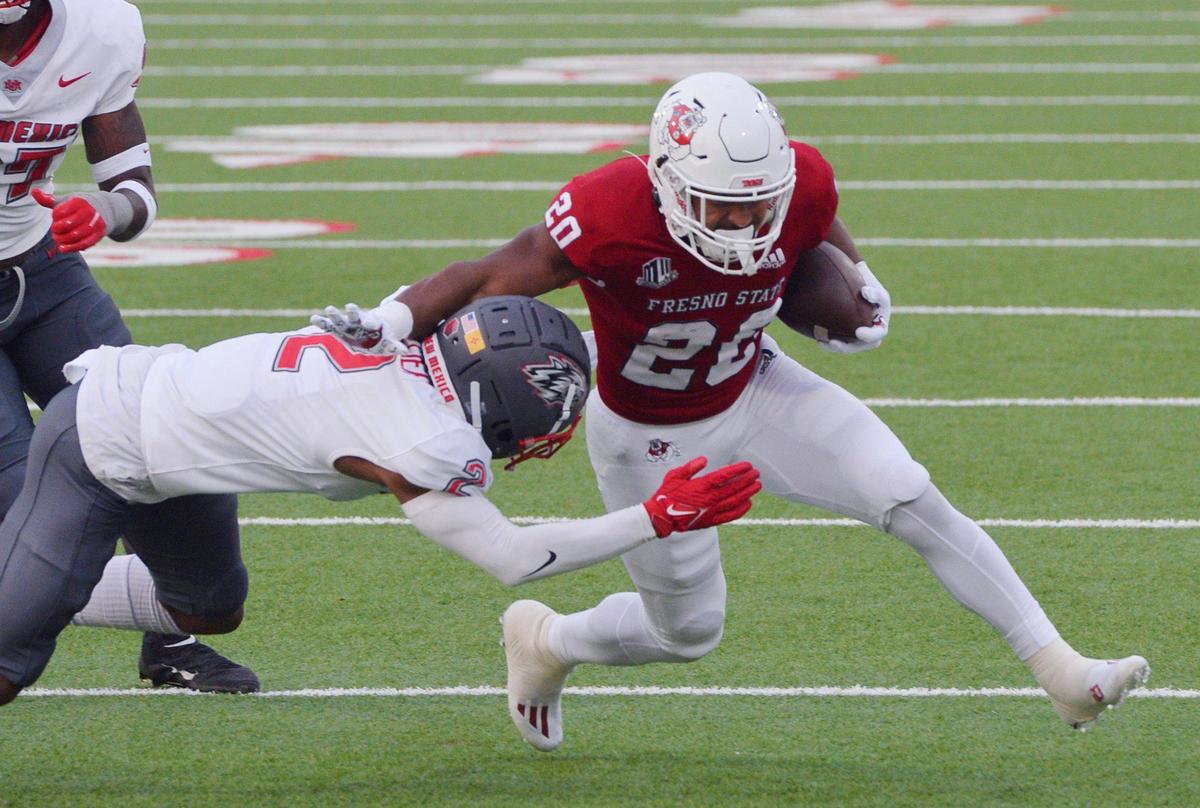 Fresno State running back Ronnie Rivers tries to run through a tackle by New Mexico’s Tony Collier in the Bulldogs 34-7 victory over the Lobos Saturday, Nov. 13, 2021 in Fresno. Rivers rushed for 71 yards on 20 plays including a 4-yard touchdown in the first quarter, the 50th touchdown of his career.