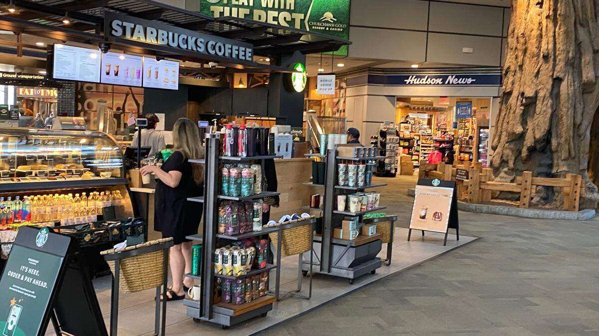 A Starbucks coffee stand and a Hudson News store, in the background, both occupy space in the lobby at Fresno Yosemite International Airport on Wednesday, April 26, 2023. New concessions contracts will bring changes to food, beverage and retail offerings available at the airport over the next 12 months.