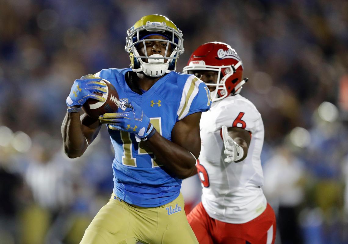 UCLA wide receiver Theo Howard (14) makes a touchdown catch in front of Fresno State defensive back Tank Kelly during the first half of an NCAA college football game, Saturday, Sept. 15, 2018, in Pasadena.