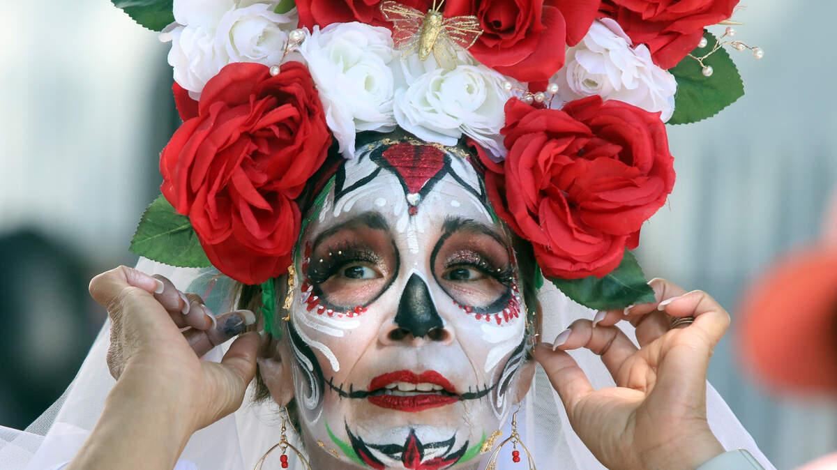Paralegal Lupe Delgado of Madera shows off a Day of the Dead crown she created during the Fiestas Patrias celebration in downtown Fresno on Sept. 24, 2023.