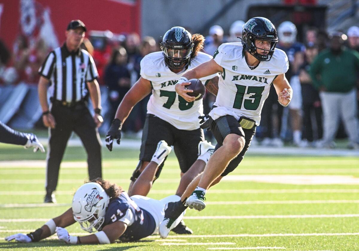 Hawaii quarterback Brayden Schager avoids getting tripped up by Fresno State’s Sione Noa on a keeper in the first half of their game at Valley Children’s Stadium in Fresno on Saturday, Nov. 2, 2024.