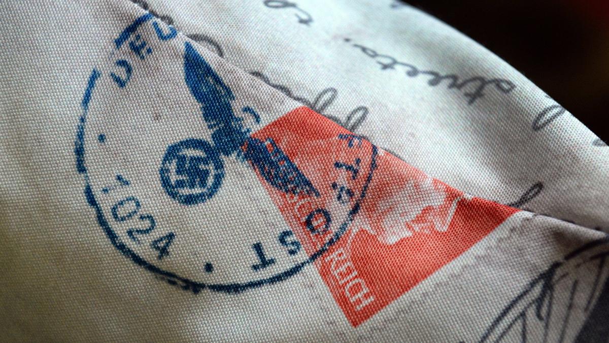 An accent throw pillow ordered from Walmart.com shows graphics of a Nazi swastika and eagle, and part of the image of an Adolf Hitler postage stamp. The pillow was ordered by the Very Reverend Ryan D. Newman, an Episcopal Priest and the Dean of the Episcopal Cathedral in Fresno, who didn’t notice the controversial graphics until he saw his daughter was playing with the pillow.