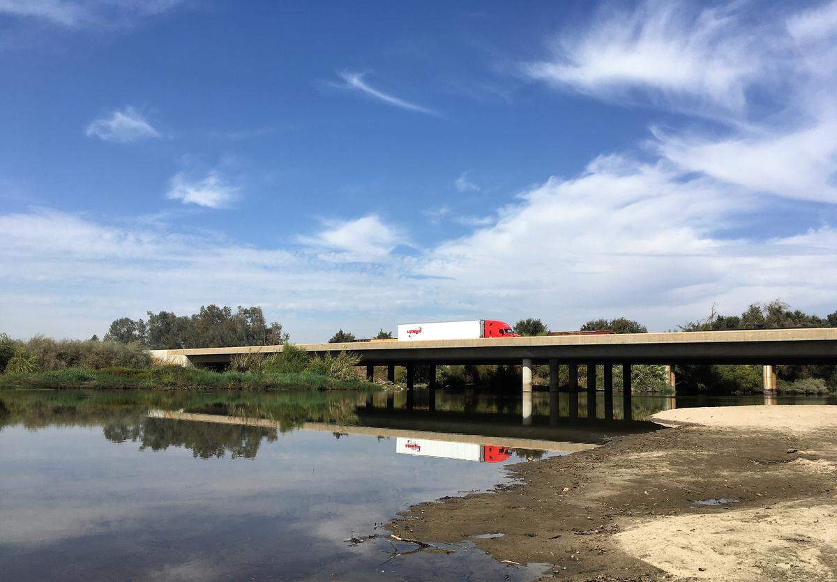 A semi truck on Highway 99 crosses the Kings River south of Kingsburg in October.