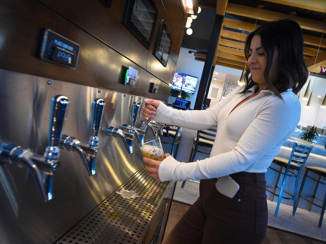 Natalie Ramirez, of Jeffrey Scott Agency, pours a craft beer at the self-serve taps at the new Blast & Brew.
