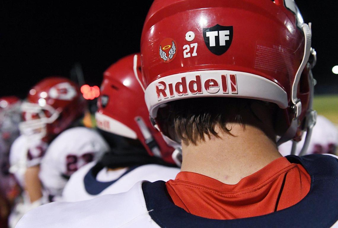 Sanger’s Hunter Pittman, right, and the entire Apaches varsity football team display Tom Flores’ initials with a Raiders shield on the back of helmets, seen at the game against San Joaquin Memorial’s Friday, April 23, 2021 in Fresno.