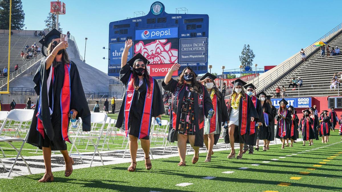 Graduating class members from the Kremen School of Education and Human Development walk into Bulldog Stadium on Friday, May 14, 2021, during the first in-person graduation since the start of the pandemic.