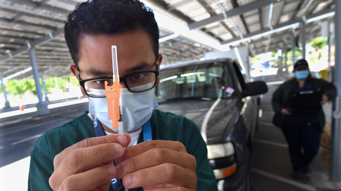 UCSF Fresno medical clerk Alex Chavez readies a Pfizer vaccine for one waiting client, Friday May 7, 2021, at the UCSF Covid Equity Project drive-up vaccination clinic at Fresno City College.