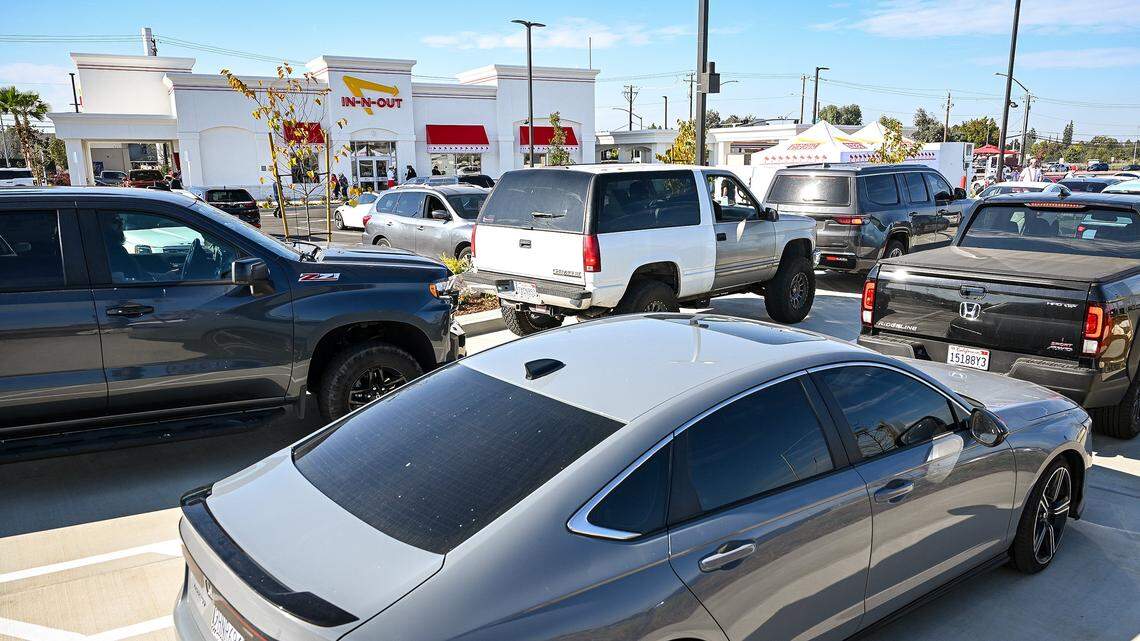 Cars line up in the drive-thru lanes of the new In-N-Out in the Fancher Creek shopping center on Clovis Avenue south of Belmont in southeast Fresno on its opening day, Wednesday, Nov. 12, 2025.