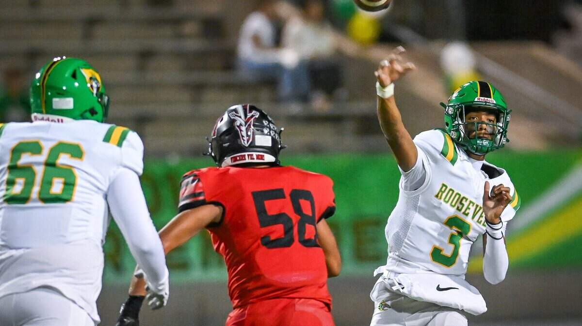 Roosevelt quarterback CJ Barker throws downfield while getting pressure from McLane's Greg Ramirez during their North Yosemite League showdown at McLane Stadium on Thursday, Oct. 9, 2025.
