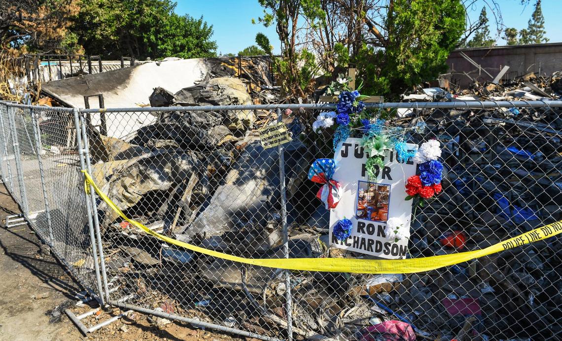 A memorial sign is posted on a chain link fence outside the burned mobile home where Ron Richardson was killed in a fire last April at Trails End Mobile Home Park in Fresno, on Monday, June 28, 2021. The City of Fresno sent a team of code enforcement officers along with investigators from the police and fire departments to conduct an inspection of the park on Monday.