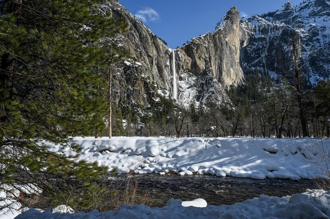 Bridalveil Fall streams down the cliffs into a Yosemite Valley covered in thick snow following days of storms that forced officials to close the park to visitors.