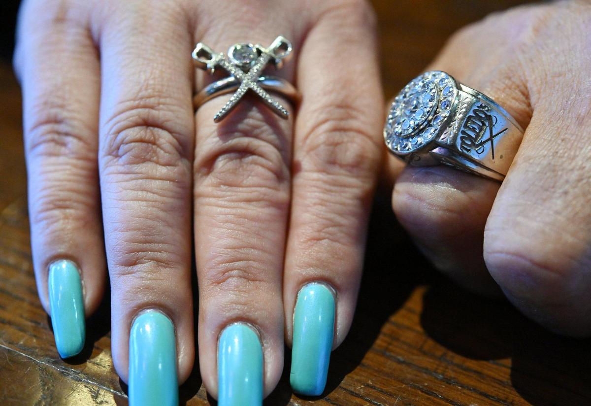 Carmen Toledo (izquierda) y su padre Sam Toledo llevan anillos personalizados con las espadas cruzadas del logotipo del restaurante y el nombre de la familia y del restaurante.