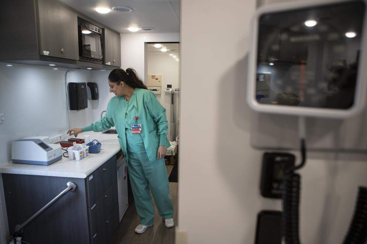 Dr. Navdeep Lehga sets up equipment in the exam room of the Saint Agnes Mobile Health Unit mobile clinic parked in the parking lot of Rojas Pierce Park in Mendota on Aug. 28, 2025. Photo by Larry Valenzuela, CalMatters/CatchLight Local