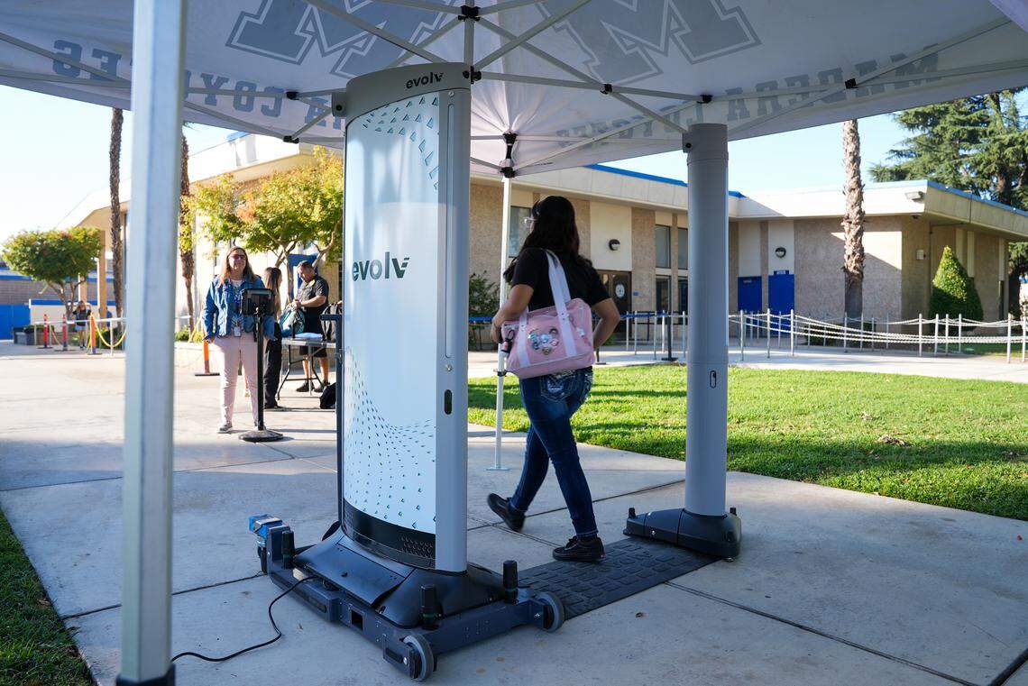 Una alumna de Madera High School pasa junto a un detector de armas Evolv Express en la entrada de la escuela sin tener que quitarse sus pertenencias. El sistema está diseñado para localizar posibles armas ocultas en bolsillos o mochilas.