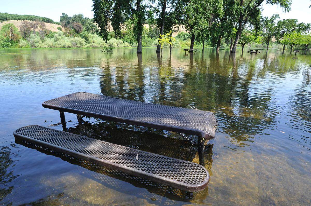 A half-submerged picnic table sits in the San Joaquin River at Lost Lake Park, Friday May 31, 2019.