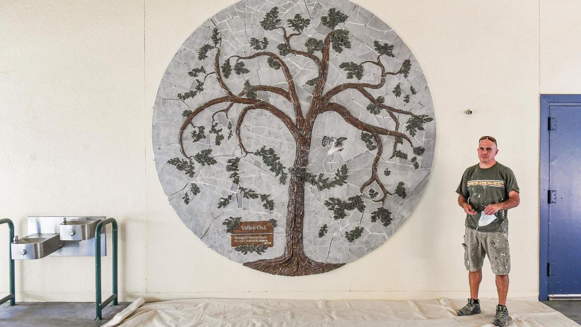 Artist David Roberts stands near the ceramic mural of a valley oak tree he is installing at Manchester GATE Elementary School in Fresno to commemorate the school’s 2020-2021 sixth-graders, at the school on Tuesday, June 1, 2021.