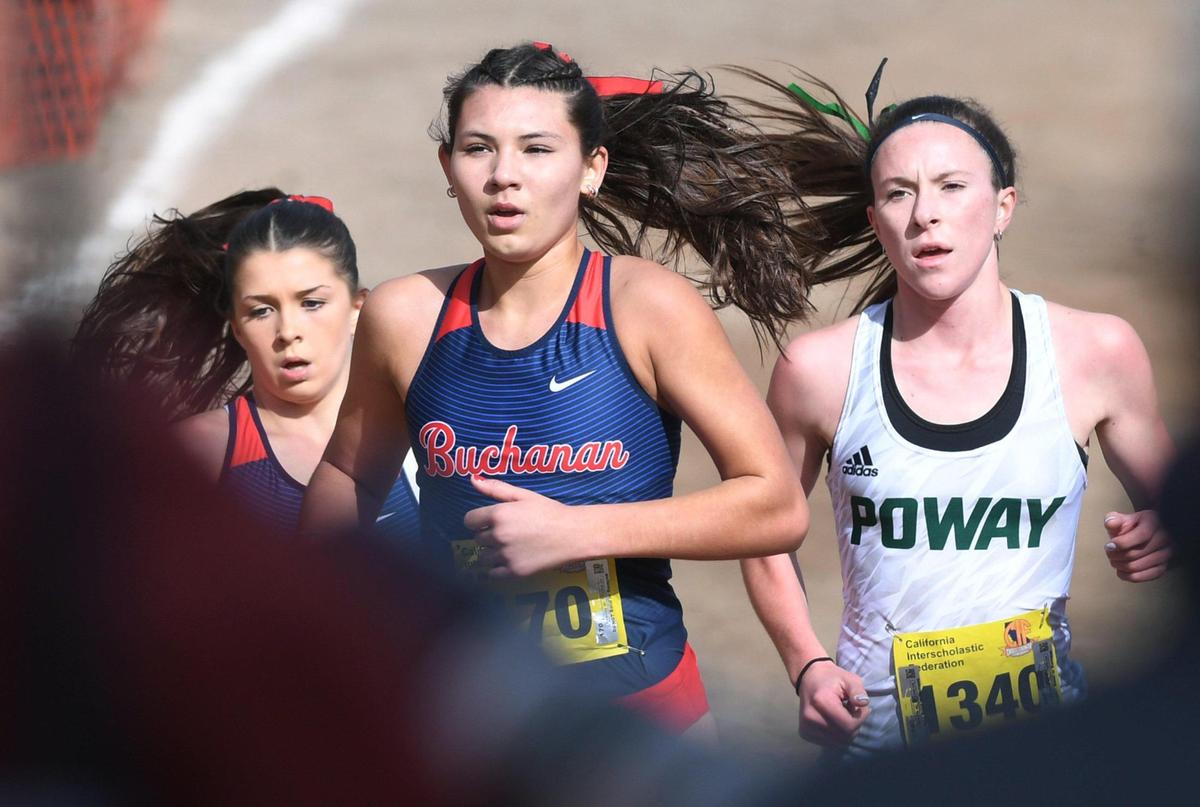 First place finisher Poway’s Tessa Buswell, right, runs behind Buchanan’s Kynzlee Buckley, left, and Elle Lomeli, center, in the CIF Girls D-I State Cross Country Championship Saturday, Nov. 26, 2022 in Fresno.