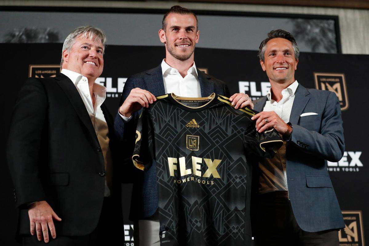 LAFC newly signed player Gareth Bale (C) holds up a jersey as he poses with lead managing owner of LAFC, Larry Berg (L), and LAFC General Manager John Thorrington (R) during a news conference at Banc of California Stadium in Los Angeles, California, USA, 11 July 2022.