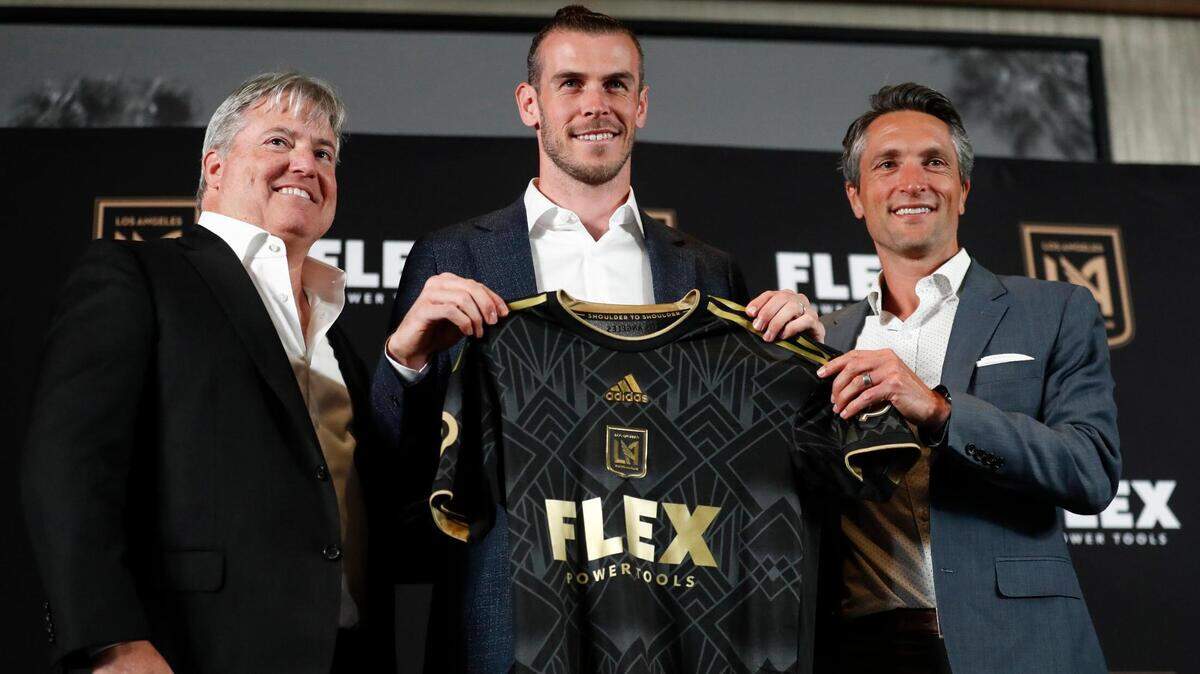 Gareth Bale holds up a jersey while posing with LAFC owner Larry Berg, left, and GM John Thorrington during a news conference announcing his signing earlier this month.