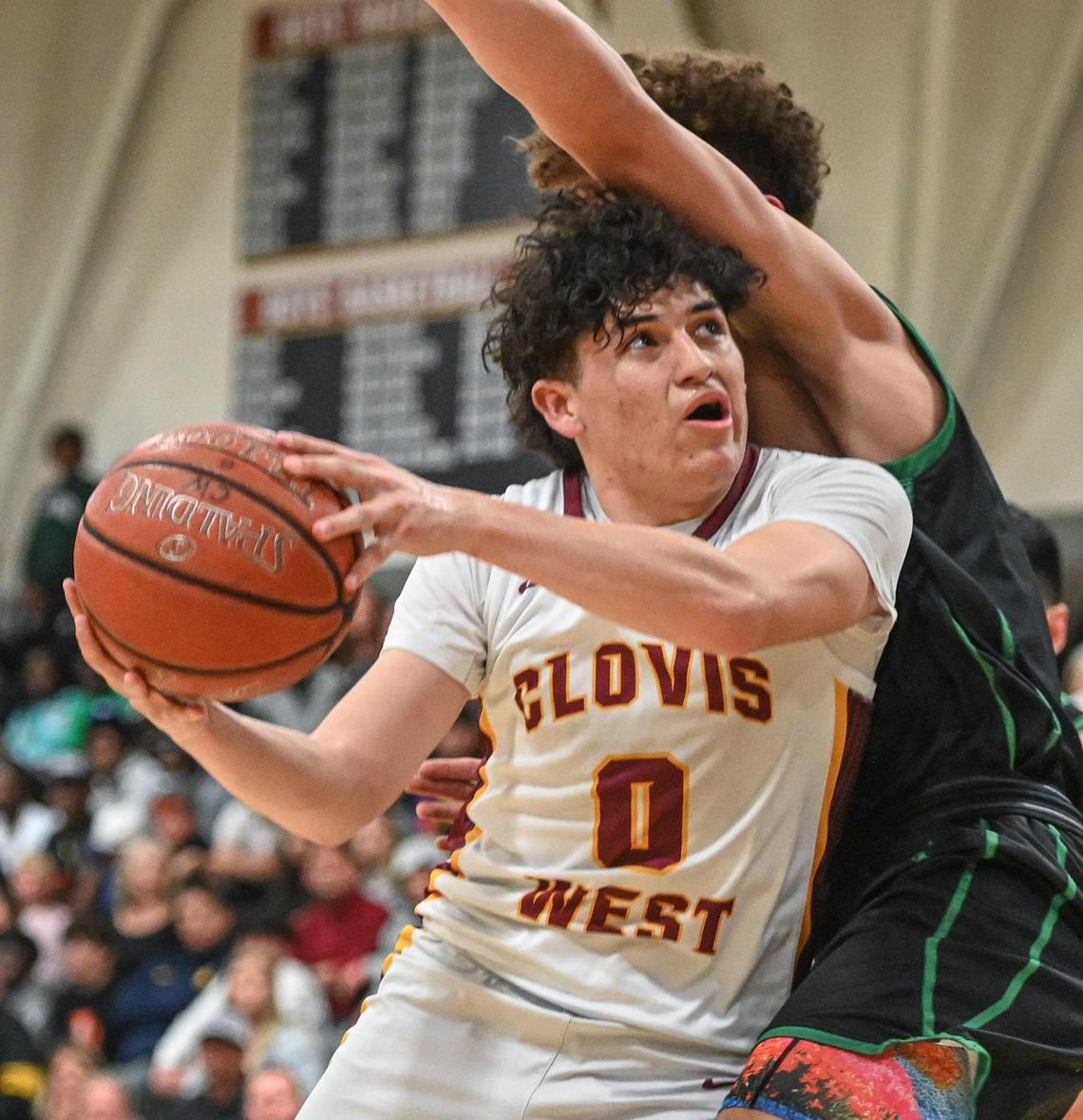 Clovis West’s Issac Martinez works his way to the hoop while guarded by St. Joseph’s Luis Marin during their Central Section Open Division championship game at Clovis West on Saturday, Feb. 26, 2022.