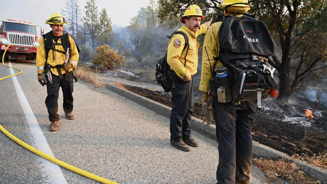 Firefighters are seen along Road 225 as the Fork Fire burns near North Fork on Wednesday, Sept. 7, 2022.
