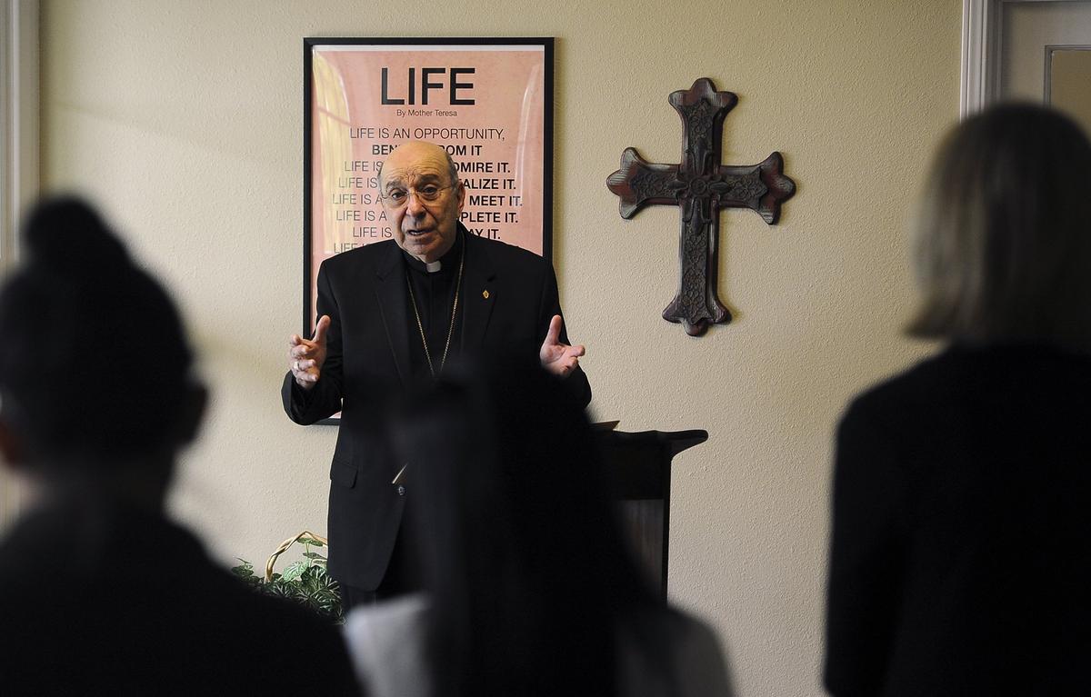 Catholic Bishop Armando Xavier Ochoa leads a private prayer circle of staff gathered inside Catholic Charities Wednesday, April 18, 2018 in Fresno. The prayer circle was was held to support Catholic Charities staff on the one-year anniversary of Kori Ali Muhammad opening fire and killing one man outside Catholic Charities and two others nearby.