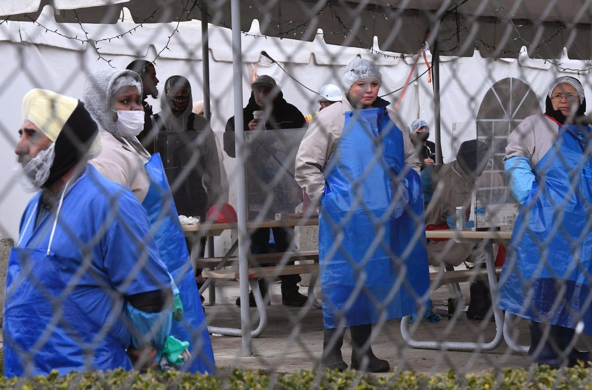 Workers at the Foster Farms facility in southeast Fresno wait outside in the cold as a Fresno Fire HAZMAT team responds to a carbon dioxide leak Friday, Dec. 23, 2022 in Fresno.