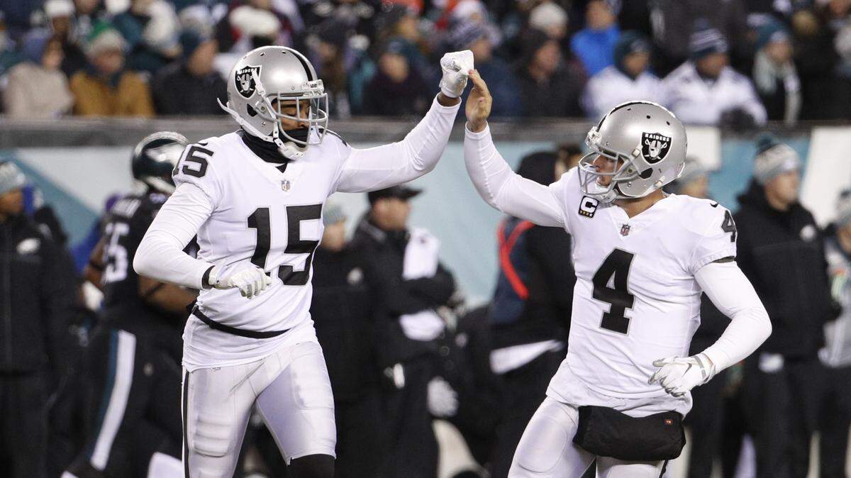 In this FILE photo, Oakland Raiders’ Derek Carr, right, celebrates with Michael Crabtree after Carr passed for a touchdown during the first half of an NFL football game against the Philadelphia Eagles, Monday, Dec. 25, 2017, in Philadelphia.