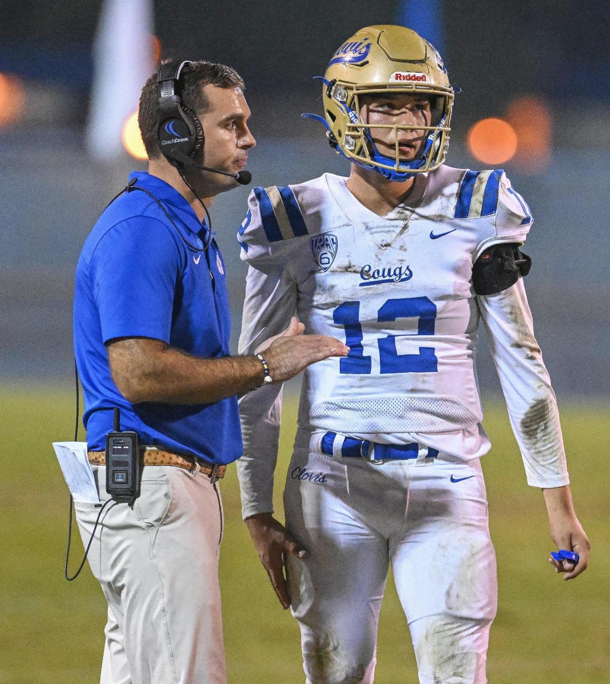 Clovis head coach Aaron Wilkins gives a play to his quarterback Deagan Rose during their game against Clovis East at Lamonica Stadium on Friday, Oct. 20, 2023.