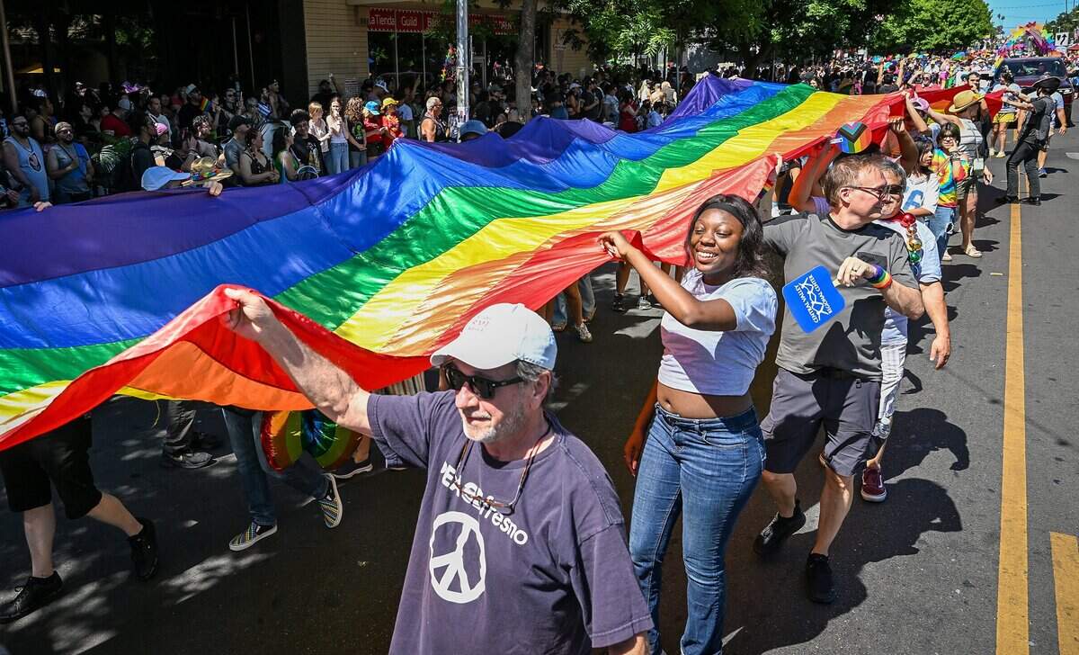 Parade participants carry a giant Pride flag for the First Congregational Church of Fresno, known as the Big Red Church, during the annual Fresno Rainbow Pride Parade and Festival in the Tower District on Saturday, June 6, 2026.