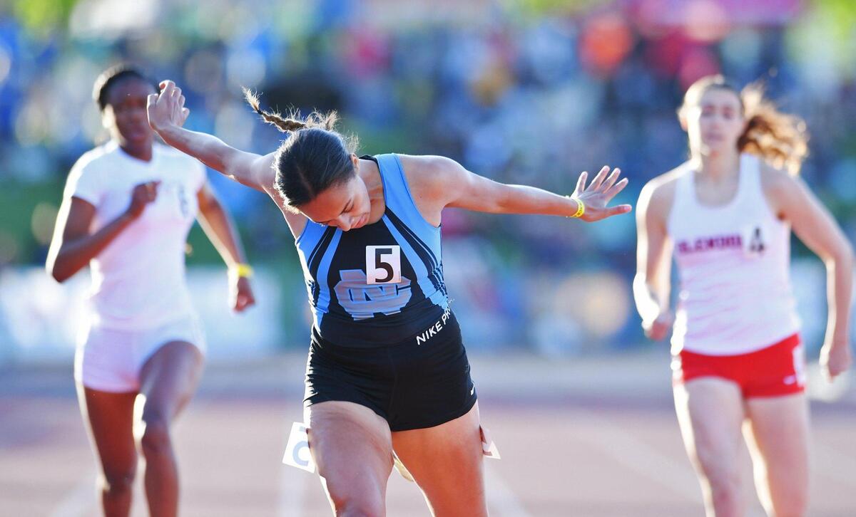 With arms outstretched Clovis North’s Takiya Cenci, center, places first in the Girls 400m Dash at the CIF State Track and Field Championship finals Saturday, May 28, 2022 in Clovis.