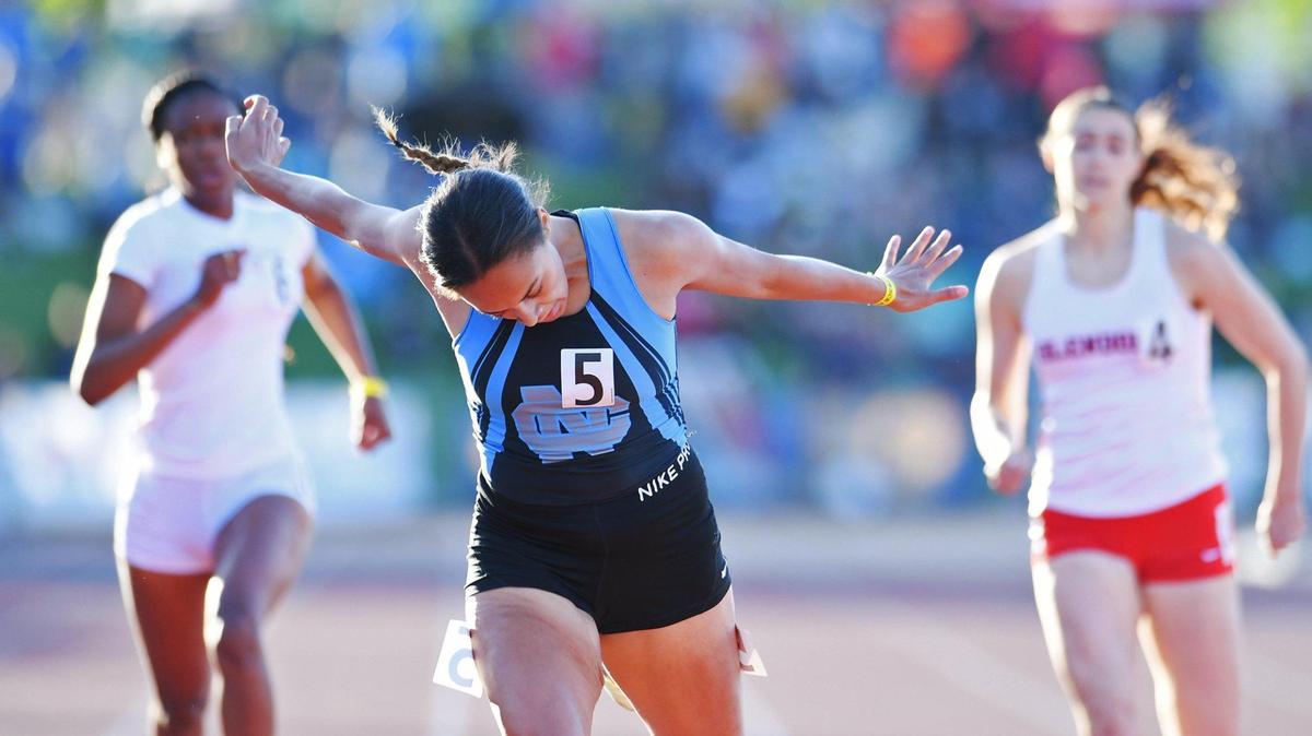 With arms outstretched Clovis North’s Takiya Cenci, center, places first in the Girls 400m Dash at the CIF State Track and Field Championship finals Saturday, May 28, 2022 in Clovis.