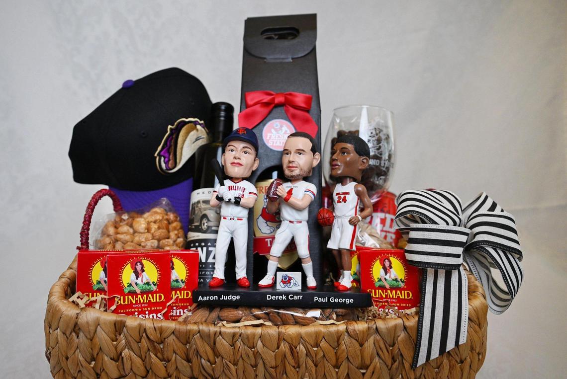 To showcase pride of Fresno through locally produced items, The Fresno Bee’s ultimate “With love, from Fresno” gift basket consists of a “Legends of Fresno State Bobblehead” of Aaron Judge, Derek Carr and Paul George, some boxes of Sun-Maid raisins, as well as chocolate-covered raisins, a Fresno Tacos baseball cap, wine from Fresno State’s winery, Enzo’s Table olive oil, and a few packs of almonds and pistachios. Photographed Friday, June 27, 2025.