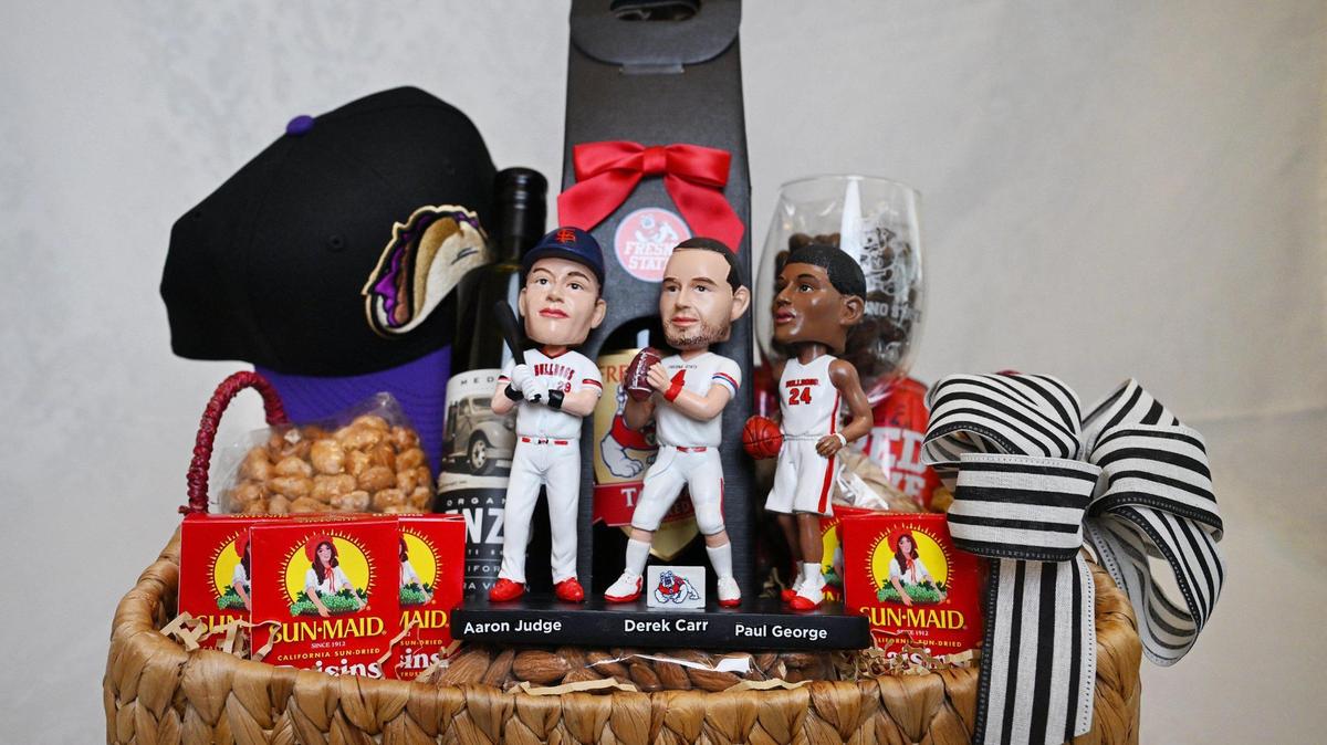 To showcase pride of Fresno through locally produced items, The Fresno Bee’s ultimate “With love, from Fresno” gift basket consists of a “Legends of Fresno State Bobblehead” of Aaron Judge, Derek Carr and Paul George, some boxes of Sun-Maid raisins, as well as chocolate-covered raisins, a Fresno Tacos baseball cap, wine from Fresno State’s winery, Enzo’s Table olive oil, and a few packs of almonds and pistachios. Photographed Friday, June 27, 2025.