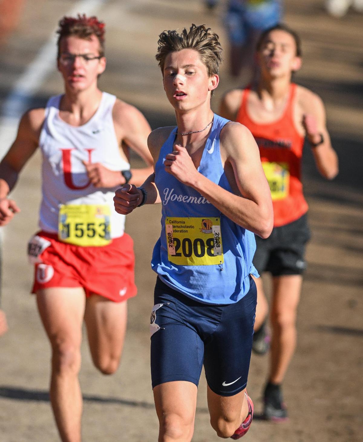 Yosemite High’s Noah Graffigna, center, stays near the front in the final mile of the boys Division V state cross country championships at Woodward Park in Fresno on Saturday, Nov. 25, 2023.