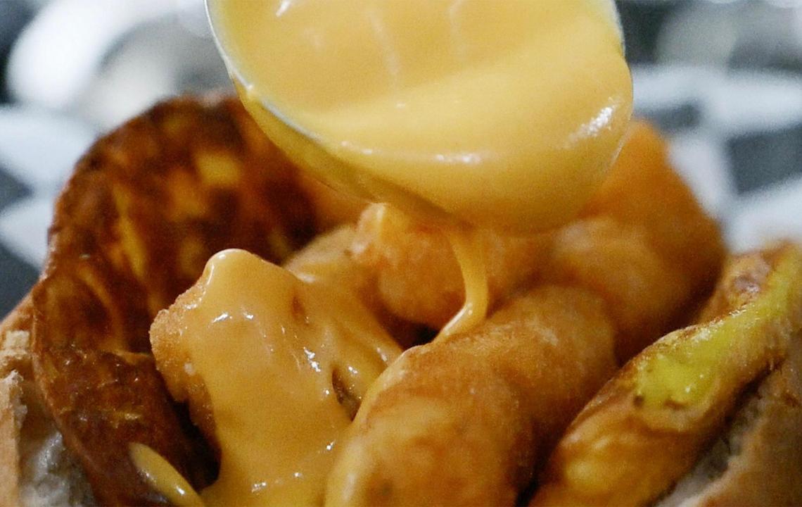Nacho cheese is poured over the breakfast dog from Plant Slayer Express, one of many vegan hotdog options for late-night eaters.