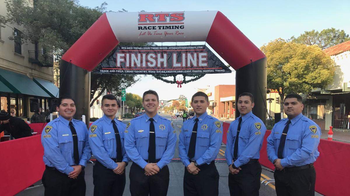 A group of CHP Explorers help at the finish line of a community run in Hanford.