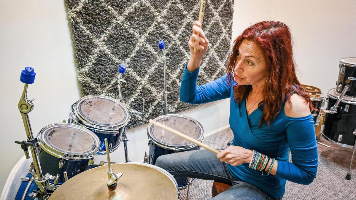 Debi Ruud, owner of Fresno Music Academy & Arts, sits down to play the drums in one of the classrooms at her new location in north Fresno on Tuesday, April 19, 2022.