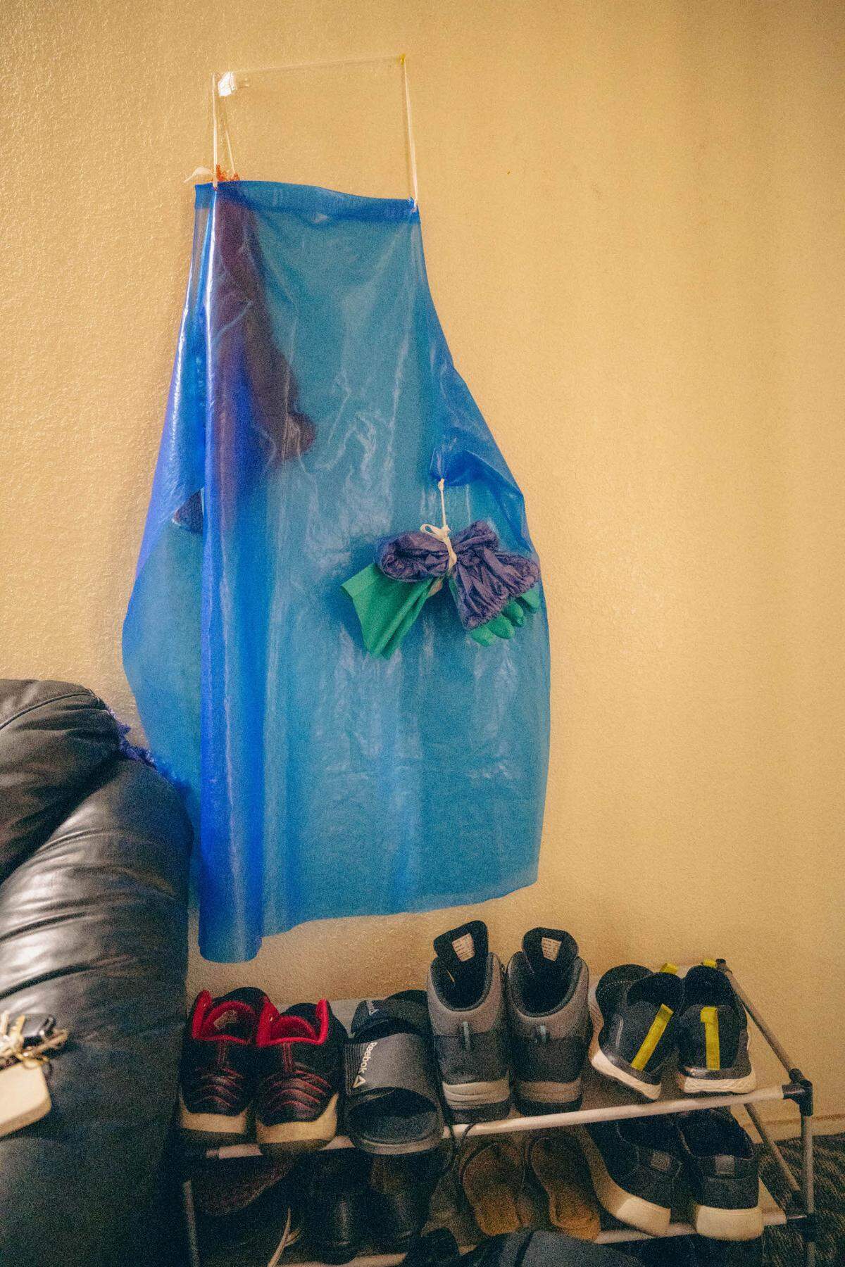 A plastic work apron and gloves hang in the apartment of Manjit Kaur in Fresno. Kaur is one of many low-income Punjabi residents in Fresno who work at area meatpacking plants. The job is particularly grueling because it requires her to work the night shift and also conflicts with her commitment as a Sikh to vegetarianism.