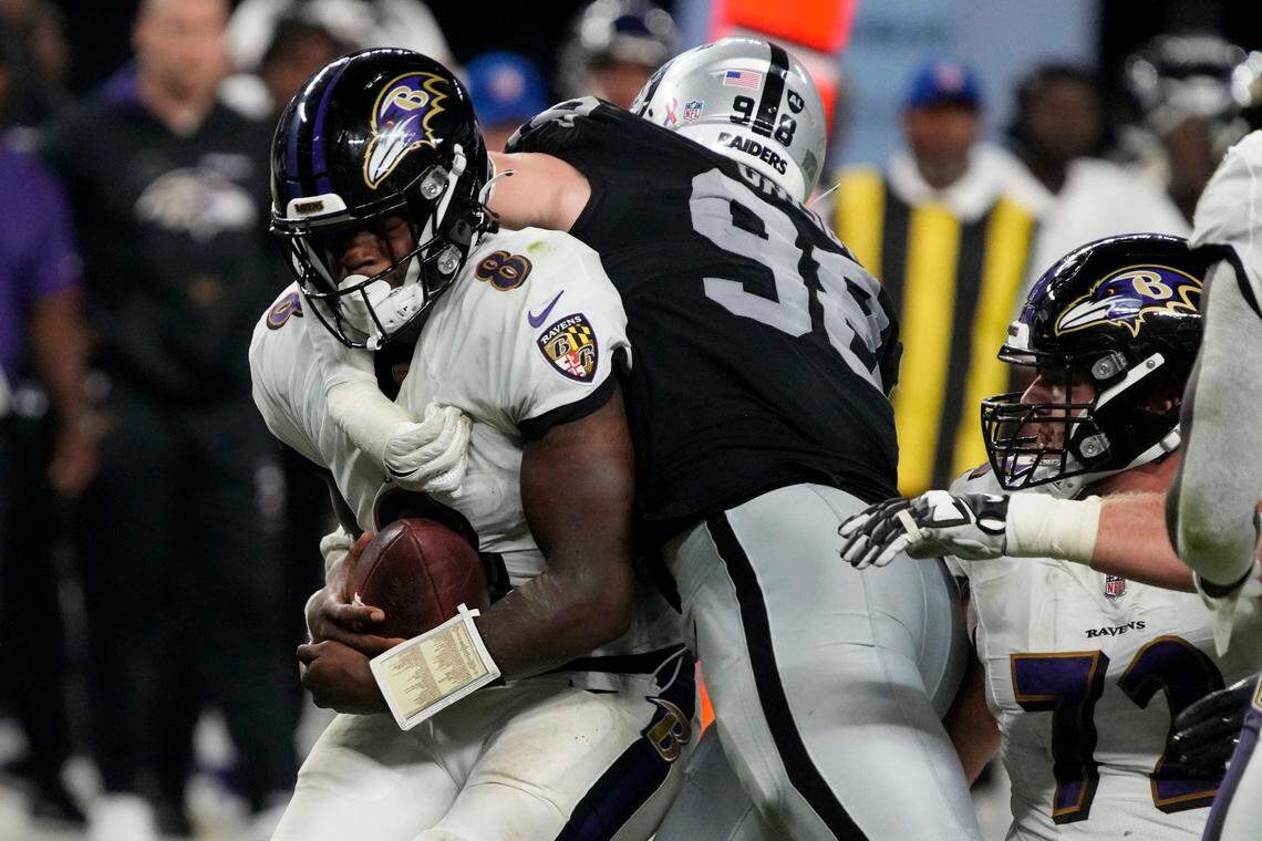 Las Vegas Raiders defensive end Maxx Crosby (98) tackles Baltimore Ravens quarterback Lamar Jackson (8) during the second half of an NFL football game, Monday, Sept. 13, 2021, in Las Vegas.